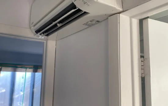 Thermopompe murale Mitsubishi Electric installée au-dessus d’un cadre de porte